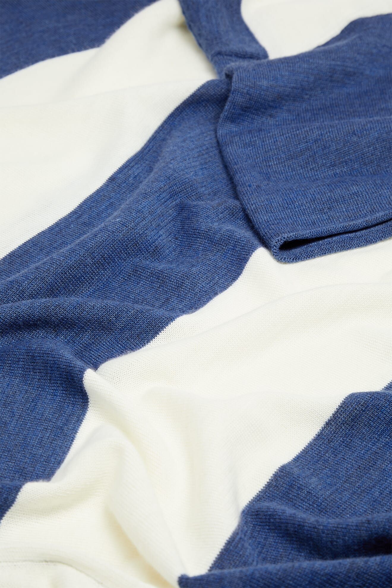 Close-up of the Merino Blend Stripe Sweater’s soft fabric, featuring wide horizontal blue and white stripes with visible folds and texture—perfect as a transitional weather sweater.