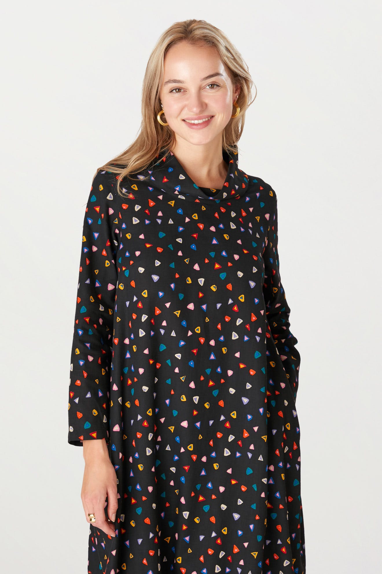 A smiling woman wearing a Little Graphic Triangle Dress.