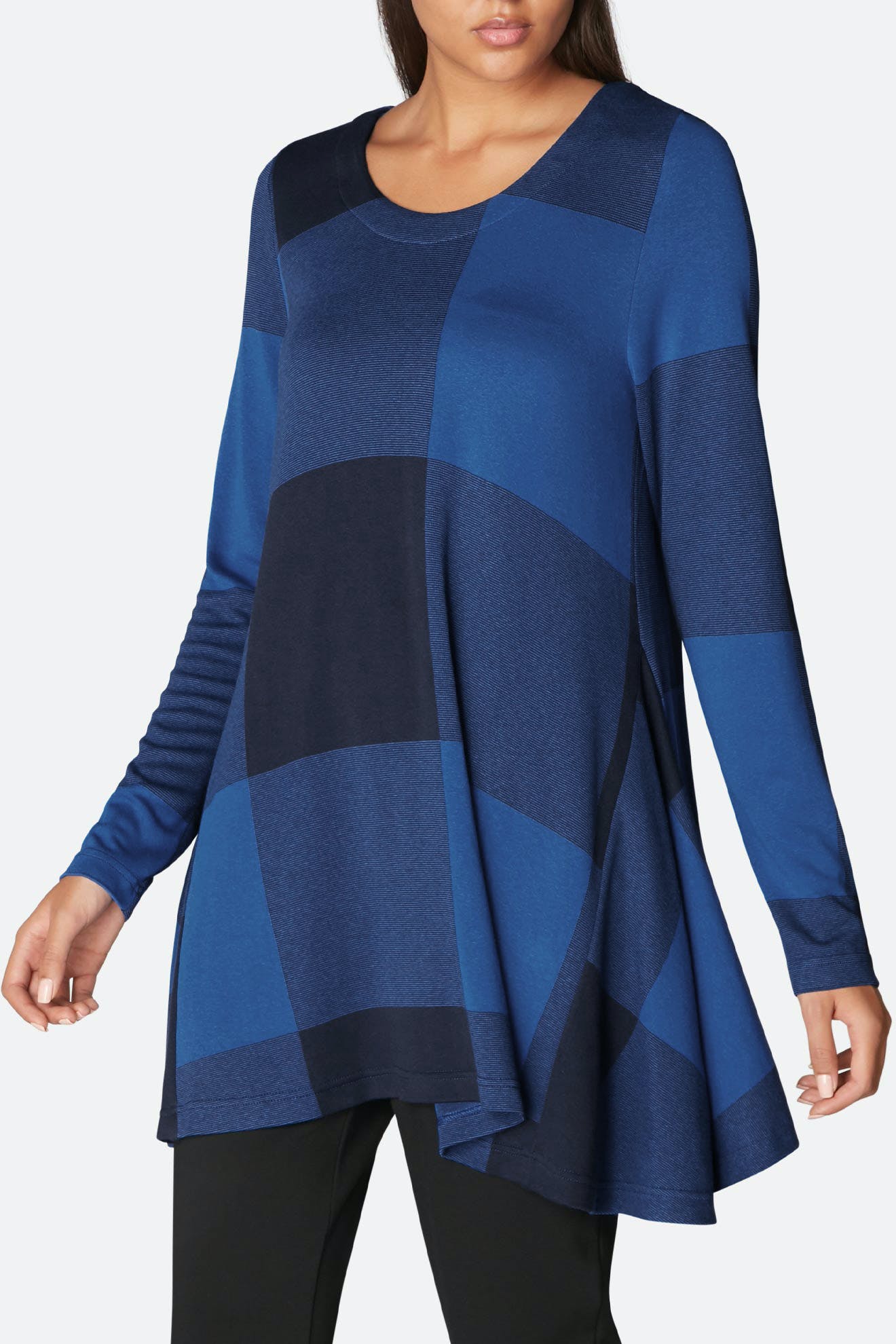 Woman wearing a Large Check Jersey Flared Top with long sleeves and a flowing hemline over black pants.
