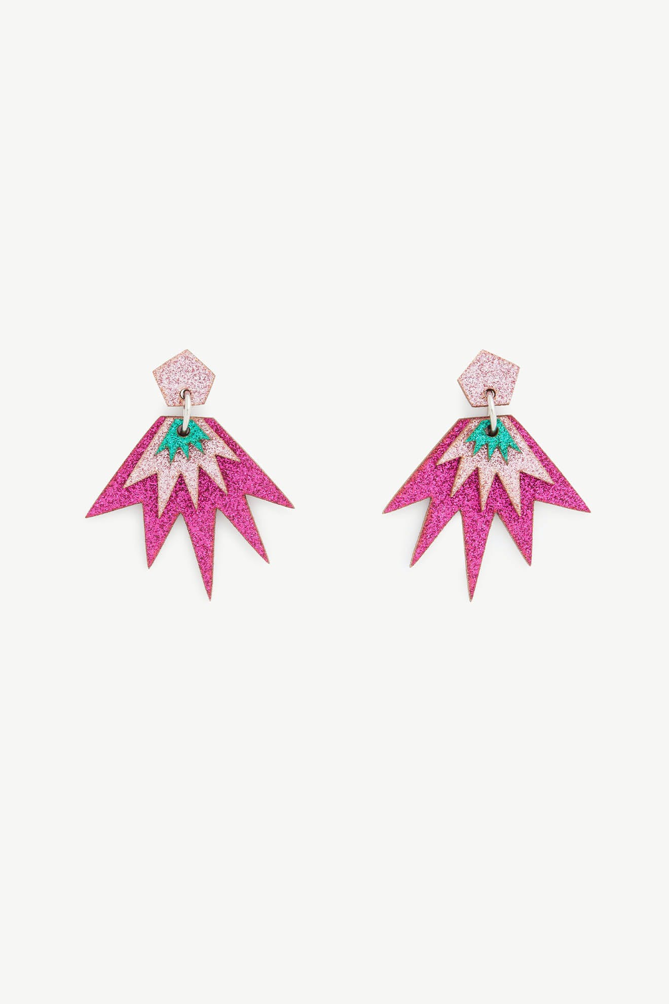 The Sparkle Drop Earrings are a vibrant pair of pink lightweight drop earrings with glittery pentagon studs and starburst-shaped dangles, featuring a green accent in the center.