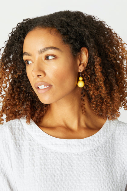 A woman wearing Double Sphere Earrings.