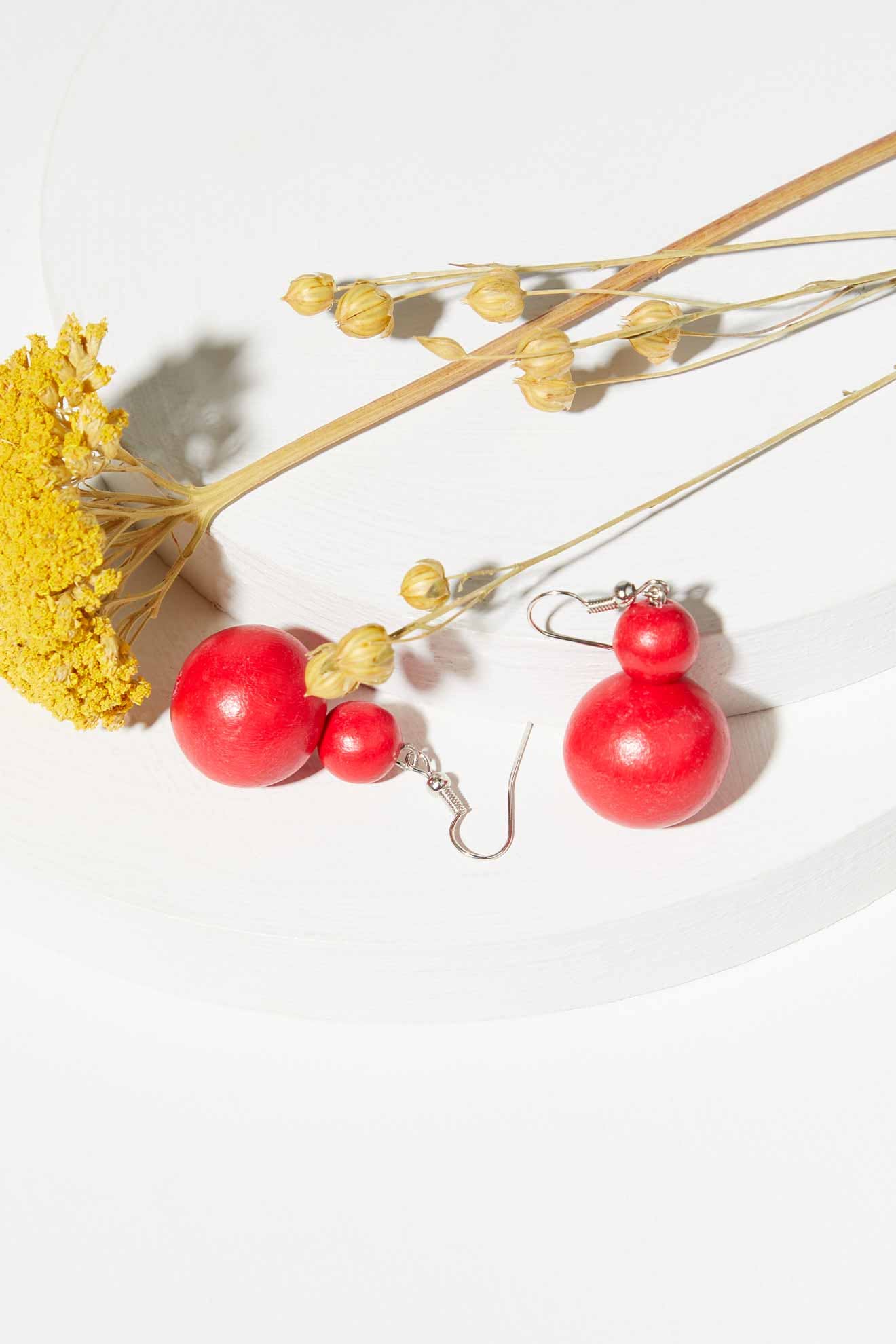 A pair of Double Sphere Earrings on a white surface.