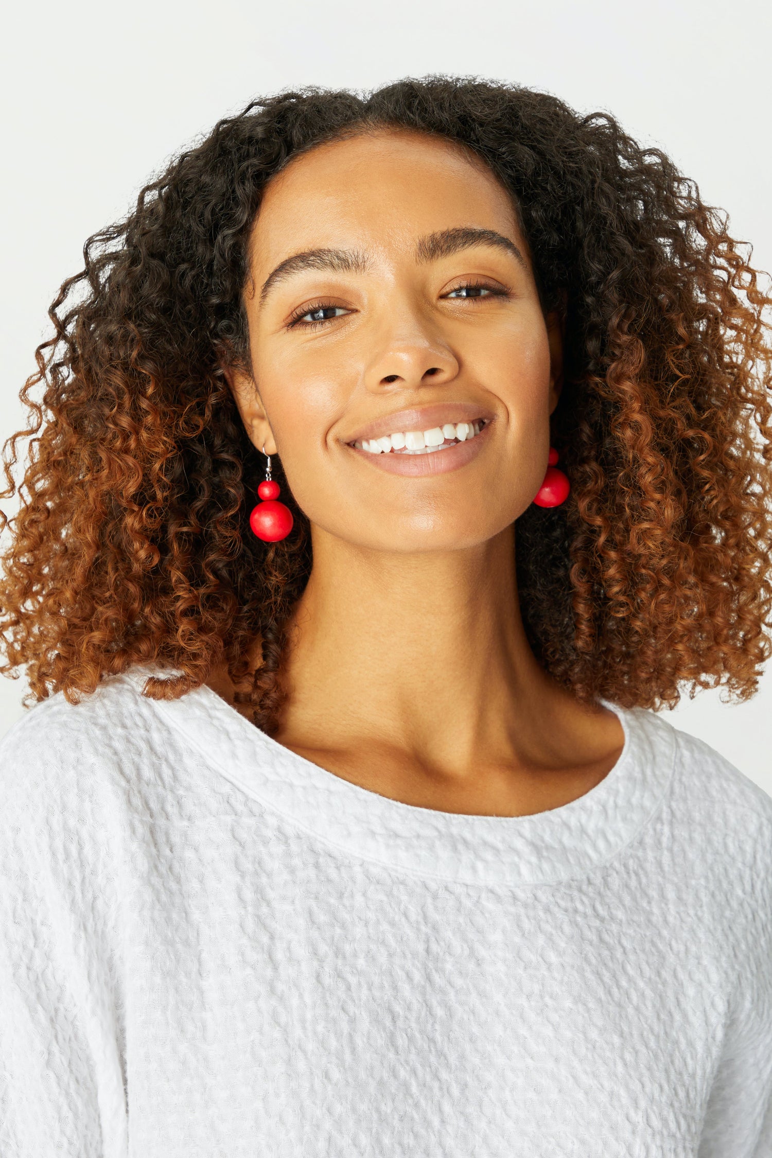 A woman wearing Double Sphere Earrings, showcasing a jewellery brand.