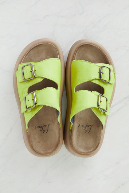 A pair of Lime Leather Flatform Sandals with buckles.