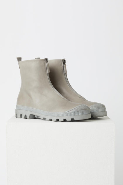 A pair of Zip Front Boots with a minimalist style on a white pedestal.