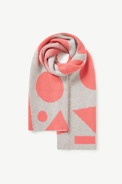 The Recycled Wool Allsorts Scarf features a rolled-up design with geometric shapes in pink and gray, crafted from recycled vegan materials in a family-run factory.