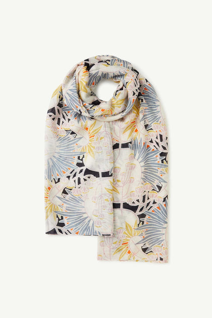 The Deco Daisy Scarf is a lightweight modal viscose scarf with a colorful, intricate floral and geometric design inspired by Kew Gardens in blue, yellow, orange, and black tones.