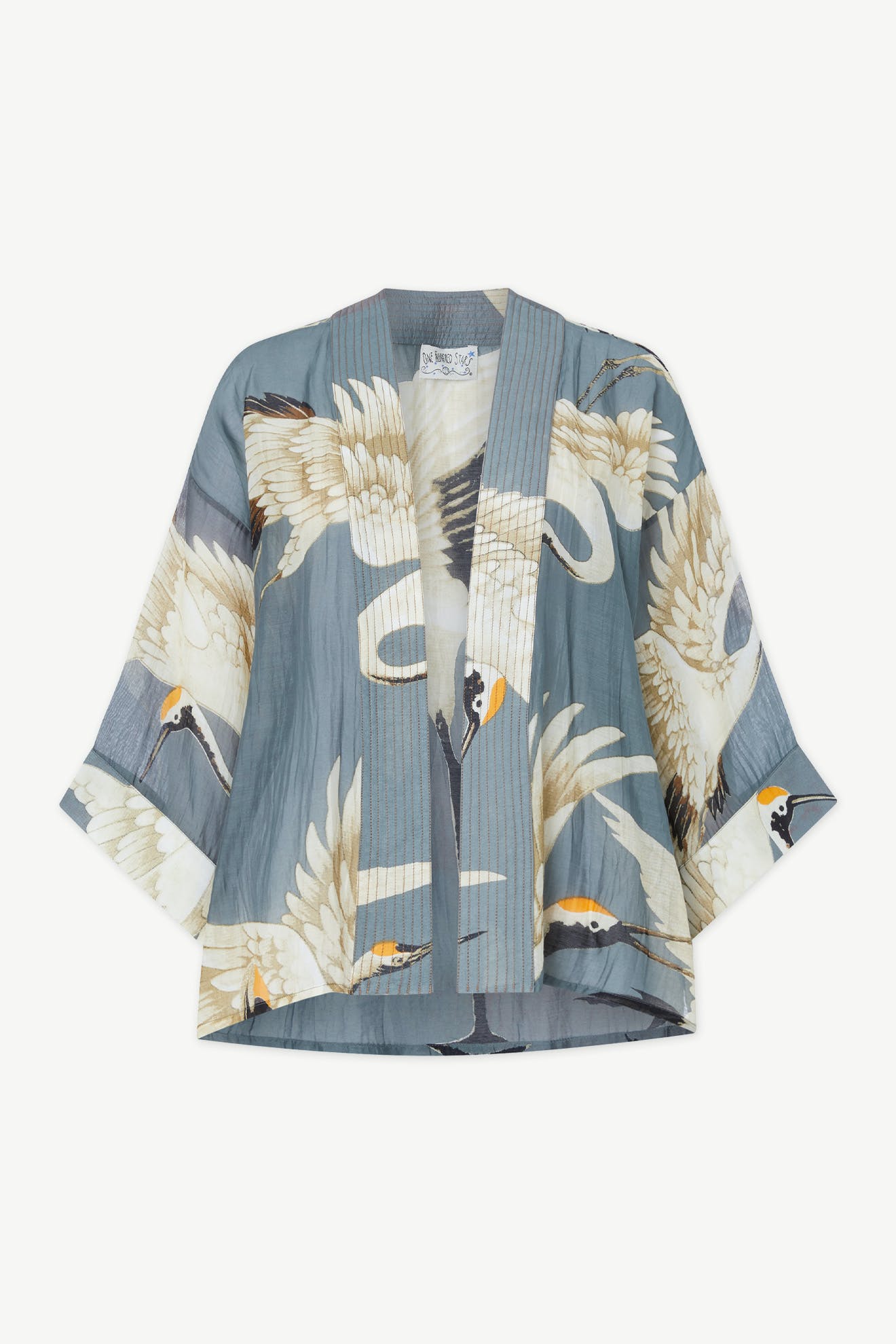 Introducing the Stork Kimono, a lightweight modal viscose piece from the exclusive Kew Gardens collaboration. This elegant jacket features a delicate stork pattern on a light blue background, complete with wide sleeves and an open front that effortlessly elevates any ensemble.