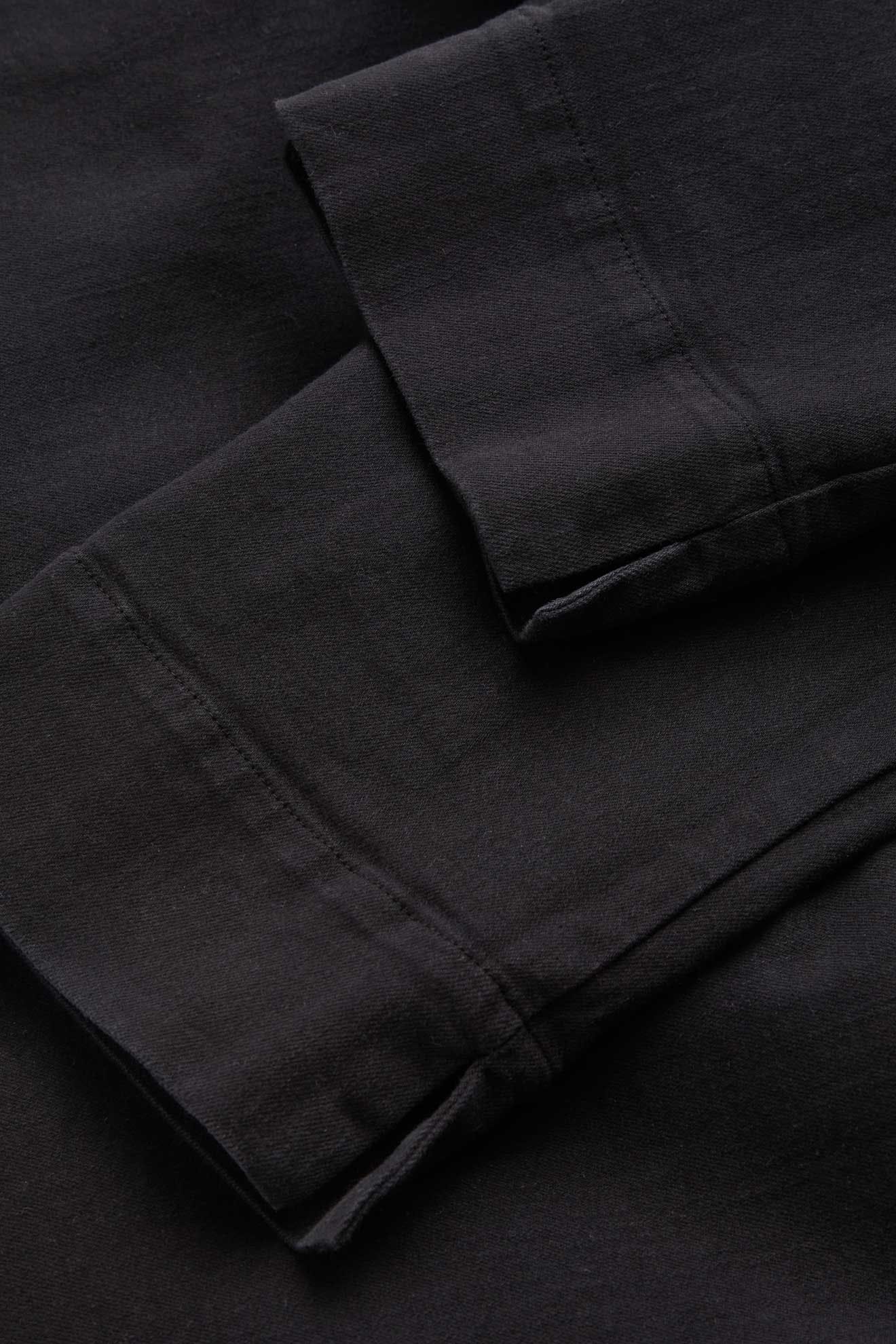 Close-up of long black fabric sleeves with visible stitching and smooth texture, similar to details found in the Stretch Cotton Twill Trouser featuring a slim-leg fit and elasticated waist.