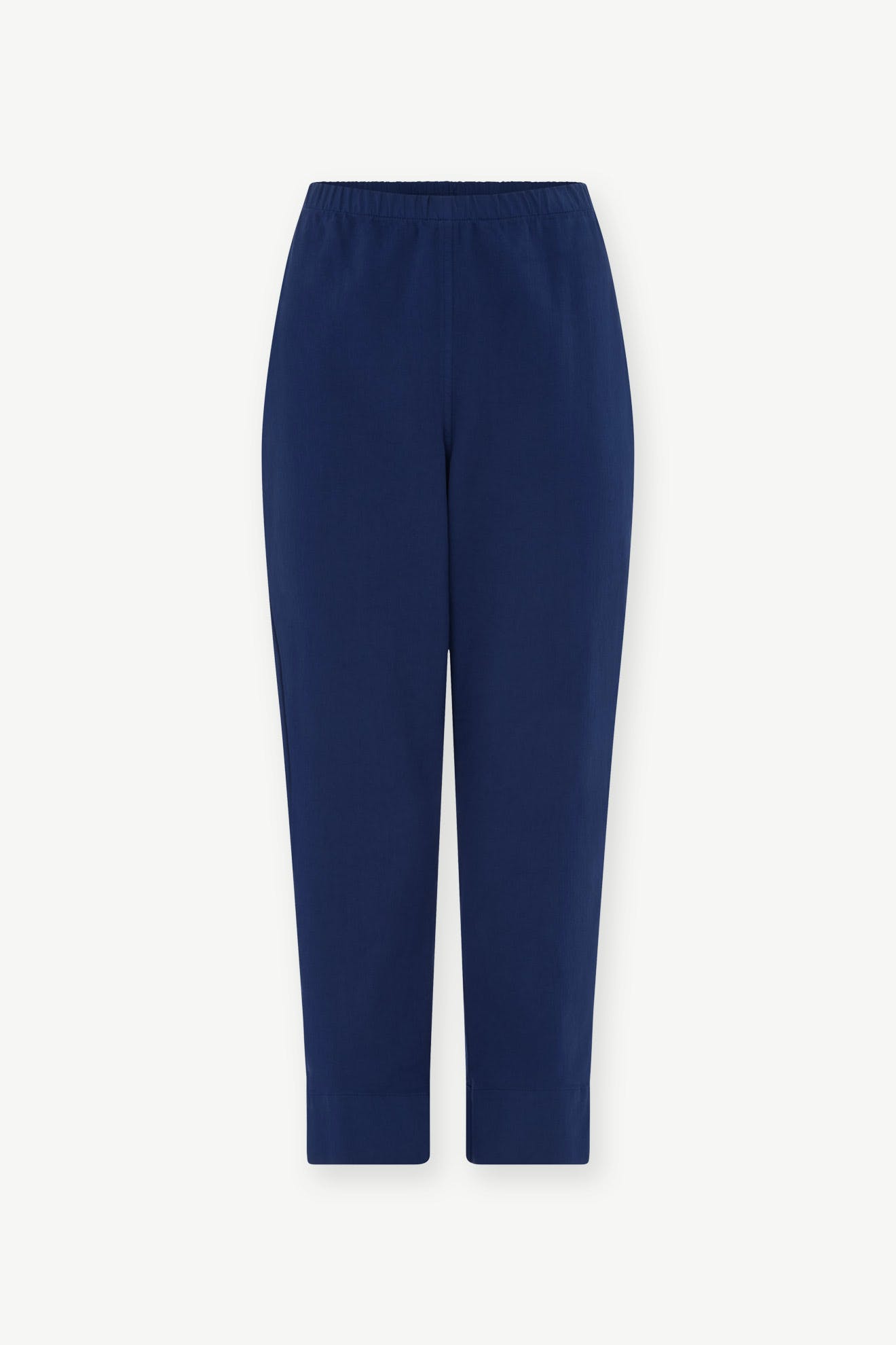 The SS22 Stretch Cotton Trouser is a pair of navy blue, slim-leg tapered trousers with an elasticated waist, shown against a plain white background.