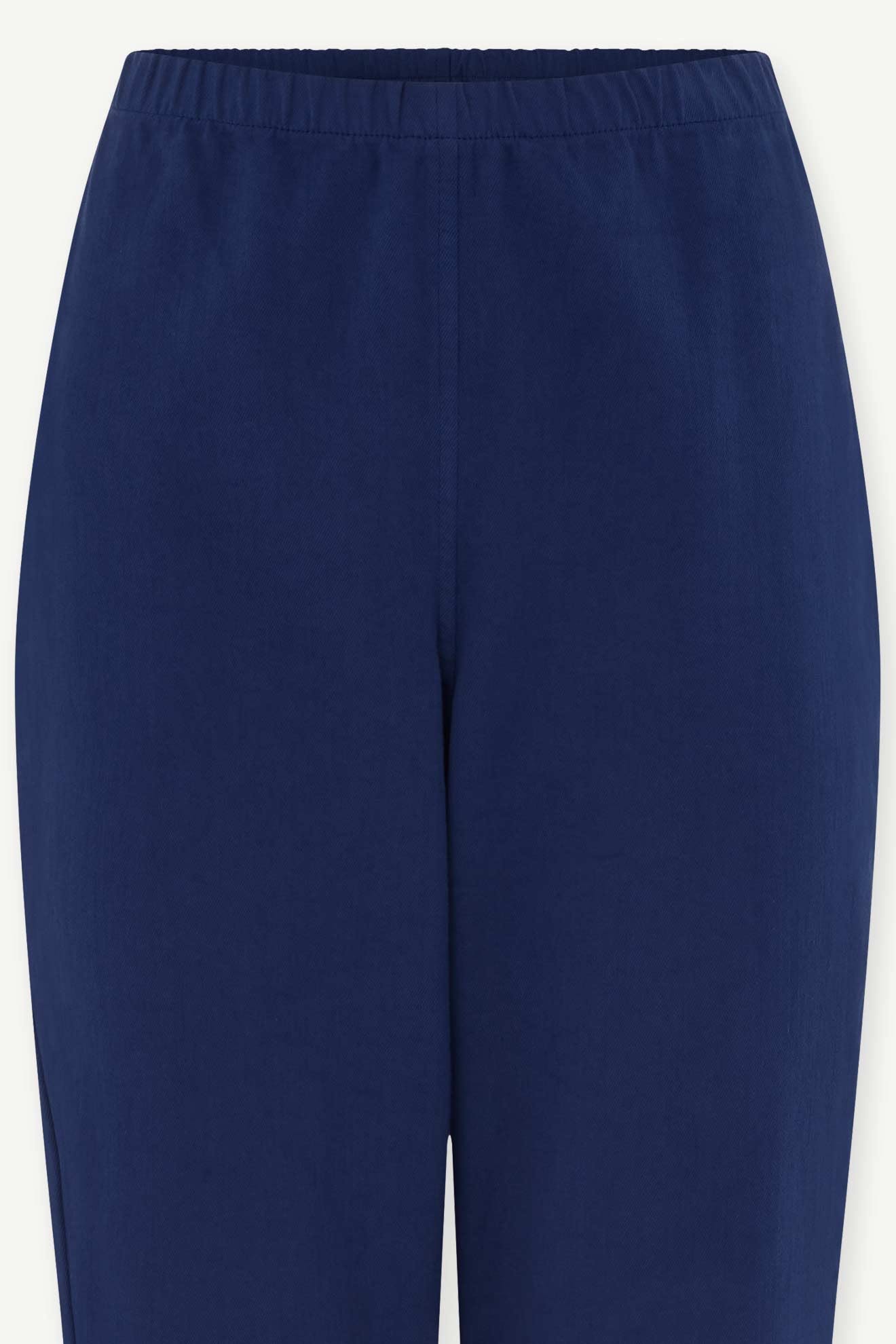 Close-up of the waist and upper legs of the SS22 Stretch Cotton Trouser in navy blue, featuring a slim-leg tapered fit, elasticated waist, and crafted from soft OEKO-TEX certified cotton.
