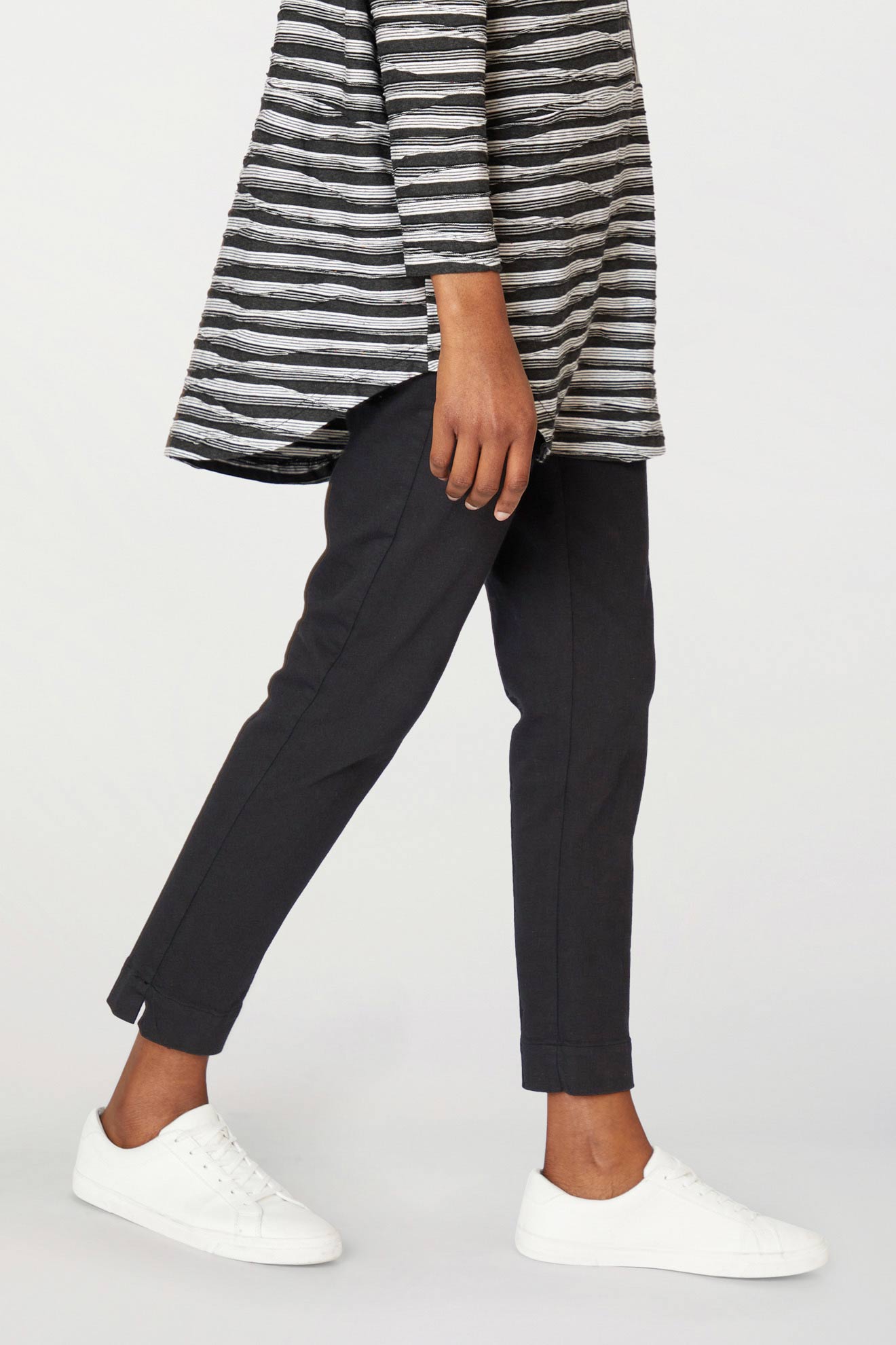 Side view of a person wearing a striped top, Stretch Twill Cotton Trousers, and white sneakers.