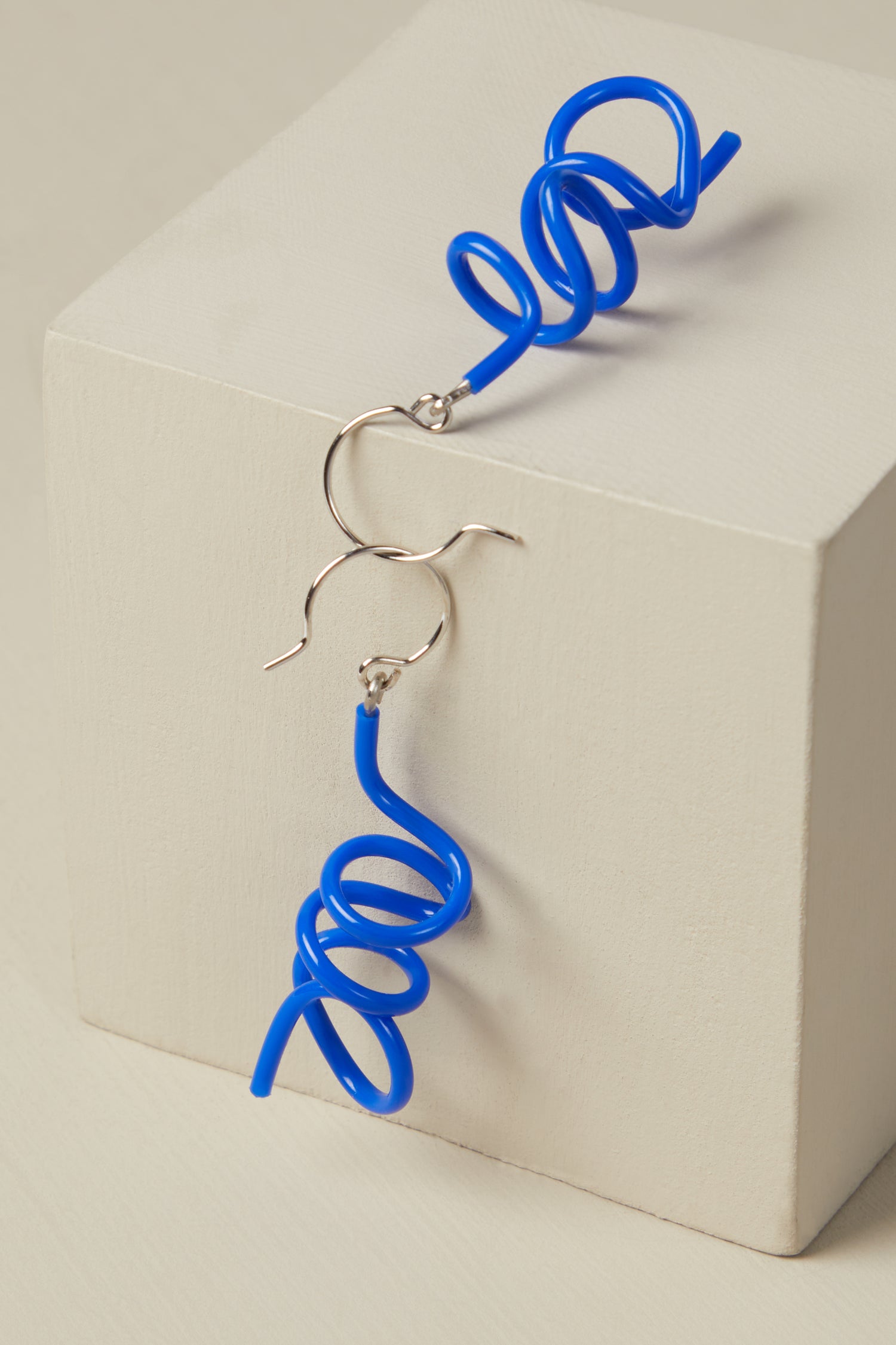 A pair of Mini Sketch Earrings crafted by a skilled jewellery maker, elegantly resting atop a box.