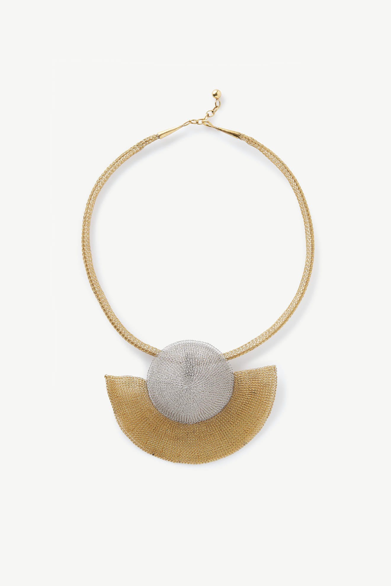 A Soninké Jewellery Crochet Half Moon Necklace featuring silver and gold finishes and a silver disc.