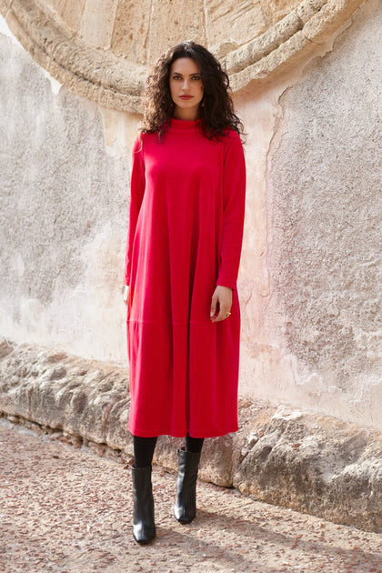 A woman wearing a low turtleneck Velvet Jersey Bubble Dress, perfect for the holiday season.