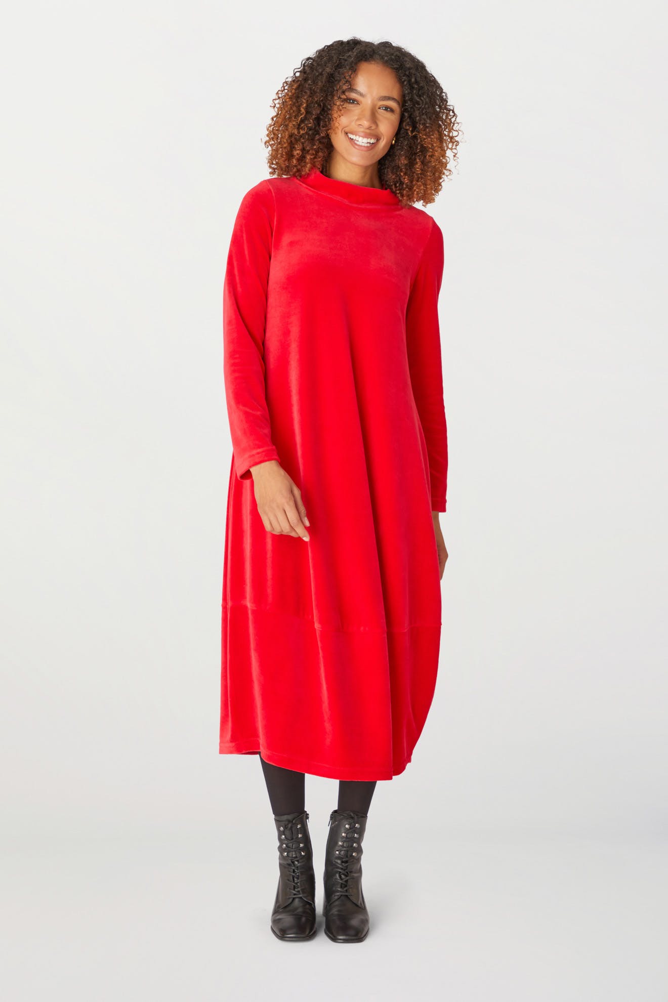 A woman wearing a Velvet Jersey Bubble Dress in a vibrant red color for the holiday season.