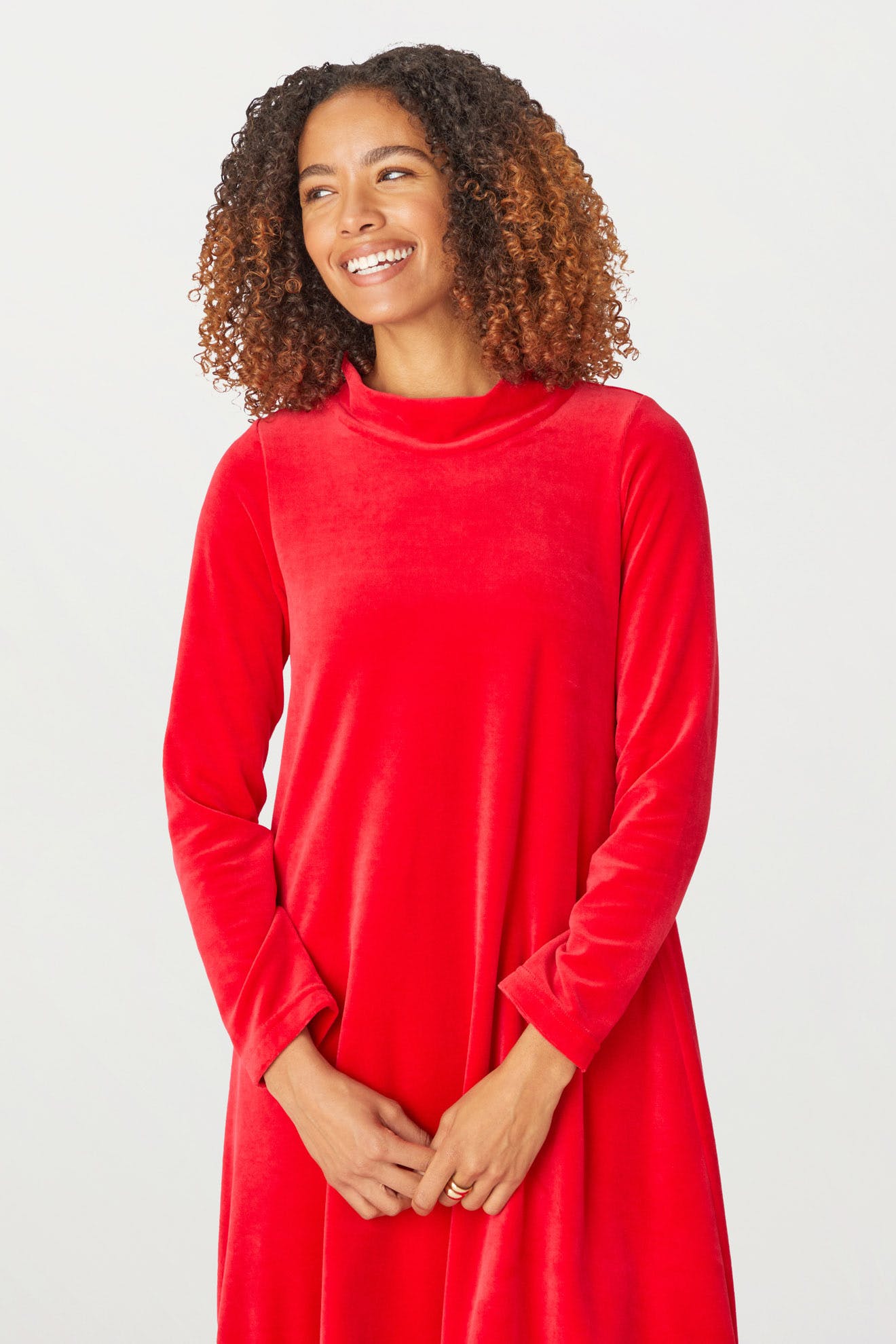 A woman wearing a Velvet Jersey Bubble Dress for the holiday season.