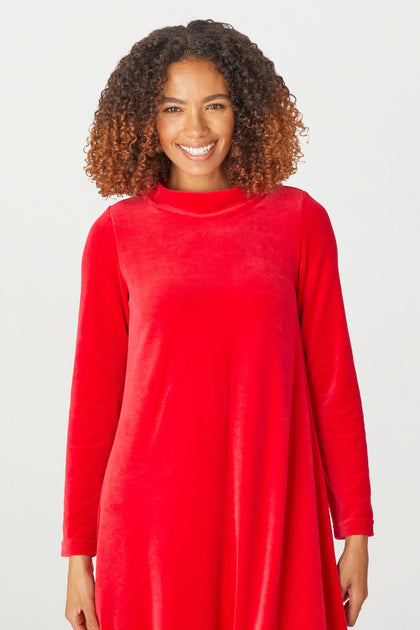 A woman dressed for the holiday season in a low turtleneck Velvet Jersey Bubble dress.
