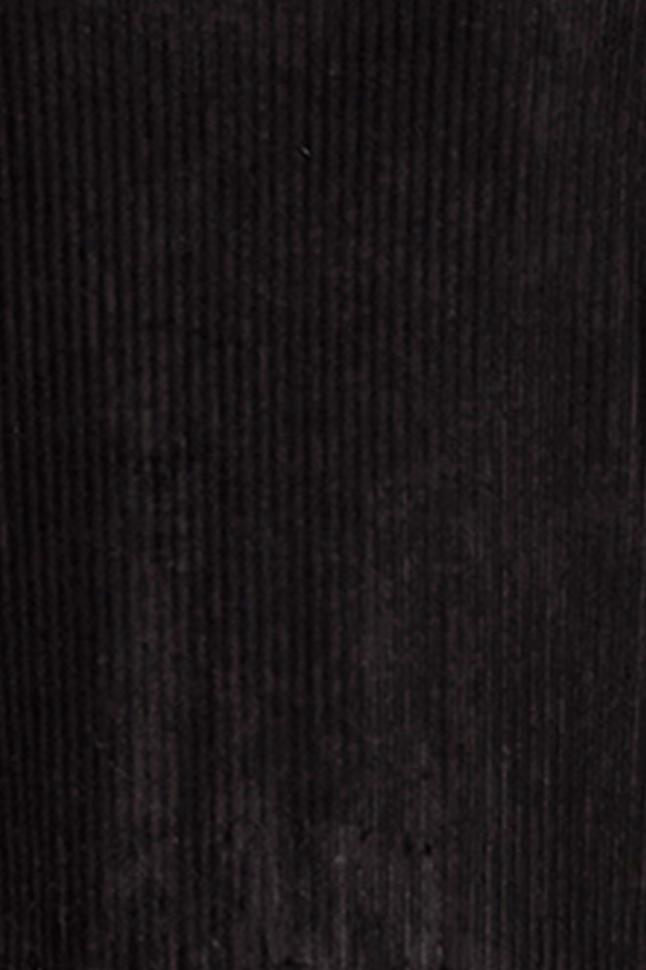 A close-up view of the Velvet Rib Jersey Top reveals its dark brown corduroy fabric, showcasing vertical ridges and a texture reminiscent of velvet.