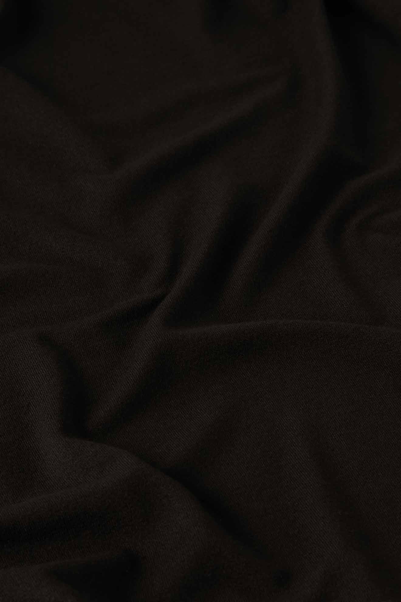 Close-up of the Fluid Crepe Jersey Relaxed Top in black, showcasing subtle folds and texture reminiscent of fluid crepe.