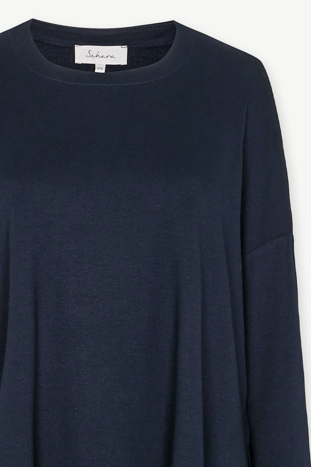 Fluid Crepe Jersey Relaxed Top in navy blue, designed with a round neckline and long sleeves, crafted from fluid crepe. It features a visible white label inside, making it a versatile wardrobe staple for any occasion.