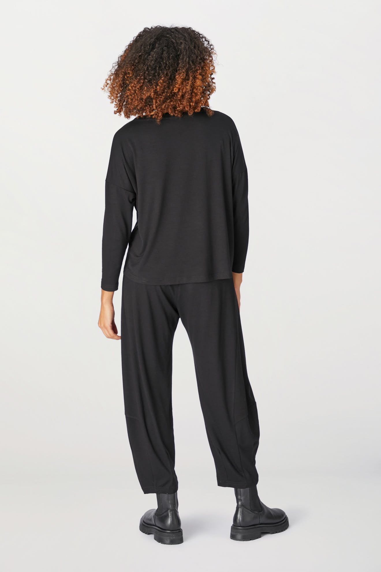 The back view of a woman wearing black pants and a Jersey Easy Top.