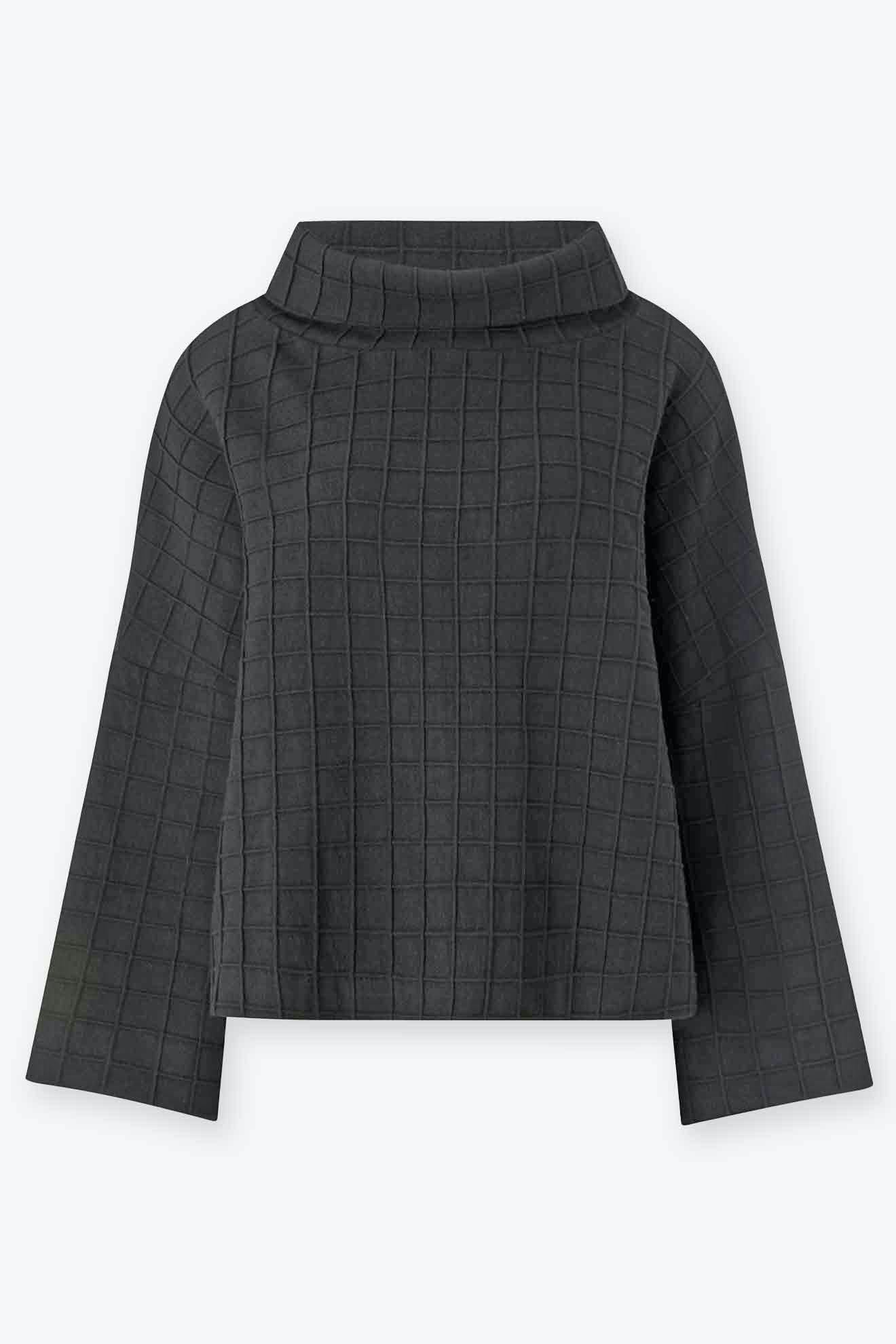 The Window Pane Wool Top is a long-sleeve, dark gray wool shirt with a grid pattern, relaxed turtleneck, and boxy silhouette, shown flat on a light background.