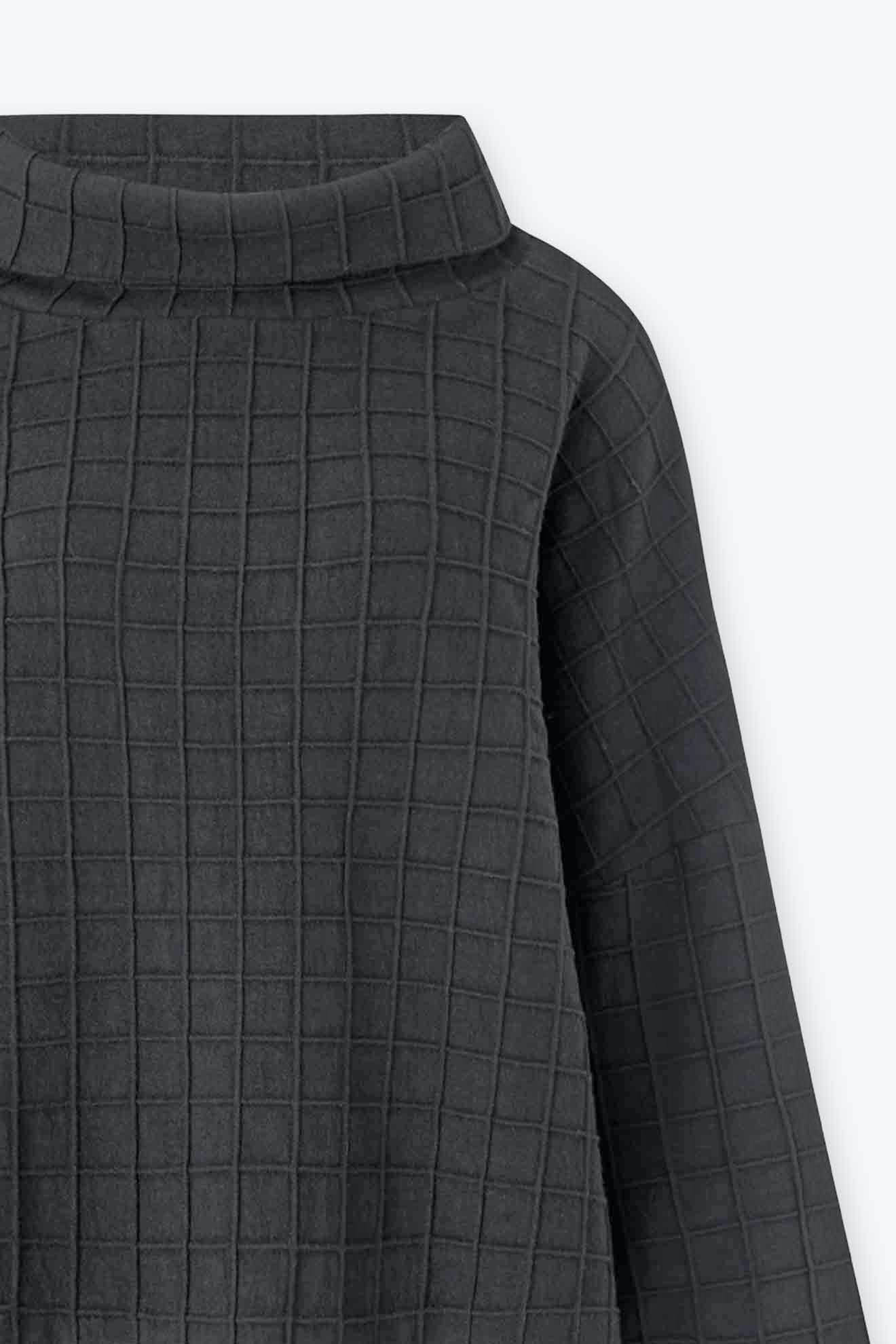 Close-up of the Window Pane Wool Top in dark gray wool with a quilted grid pattern, boxy silhouette, and wide, structured neckline.