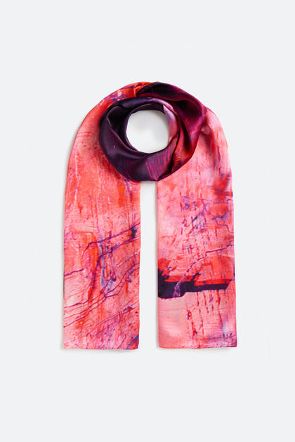 Introducing the Heavenly Calcite Scarf, a rectangular silk accessory adorned with an abstract design in captivating shades of red, pink, and purple on a plain background—ideal for anyone seeking to elevate their fashion game.