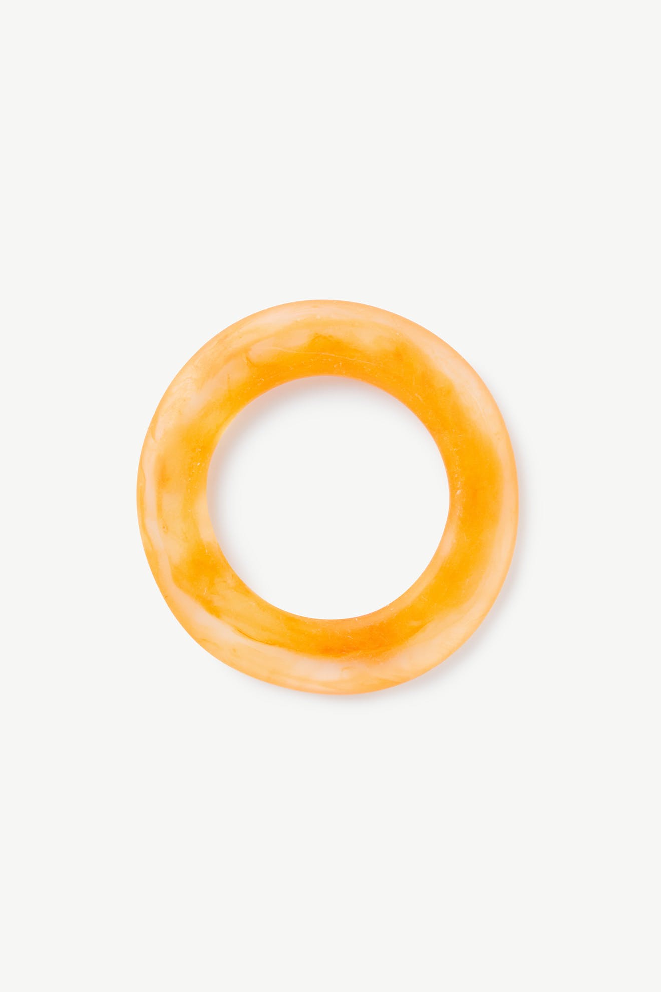 The Marbelled Bracelet is a round resin bracelet with an orange marbled design and smooth surface, shown on a plain white background.